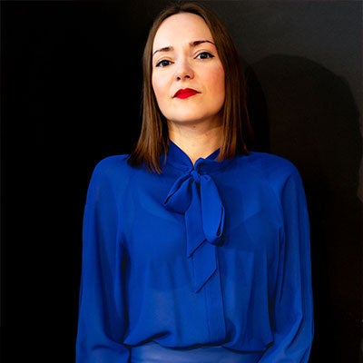 A photo of Victoria Jenkins. She has medium length brown hair and wears a blue blouse.