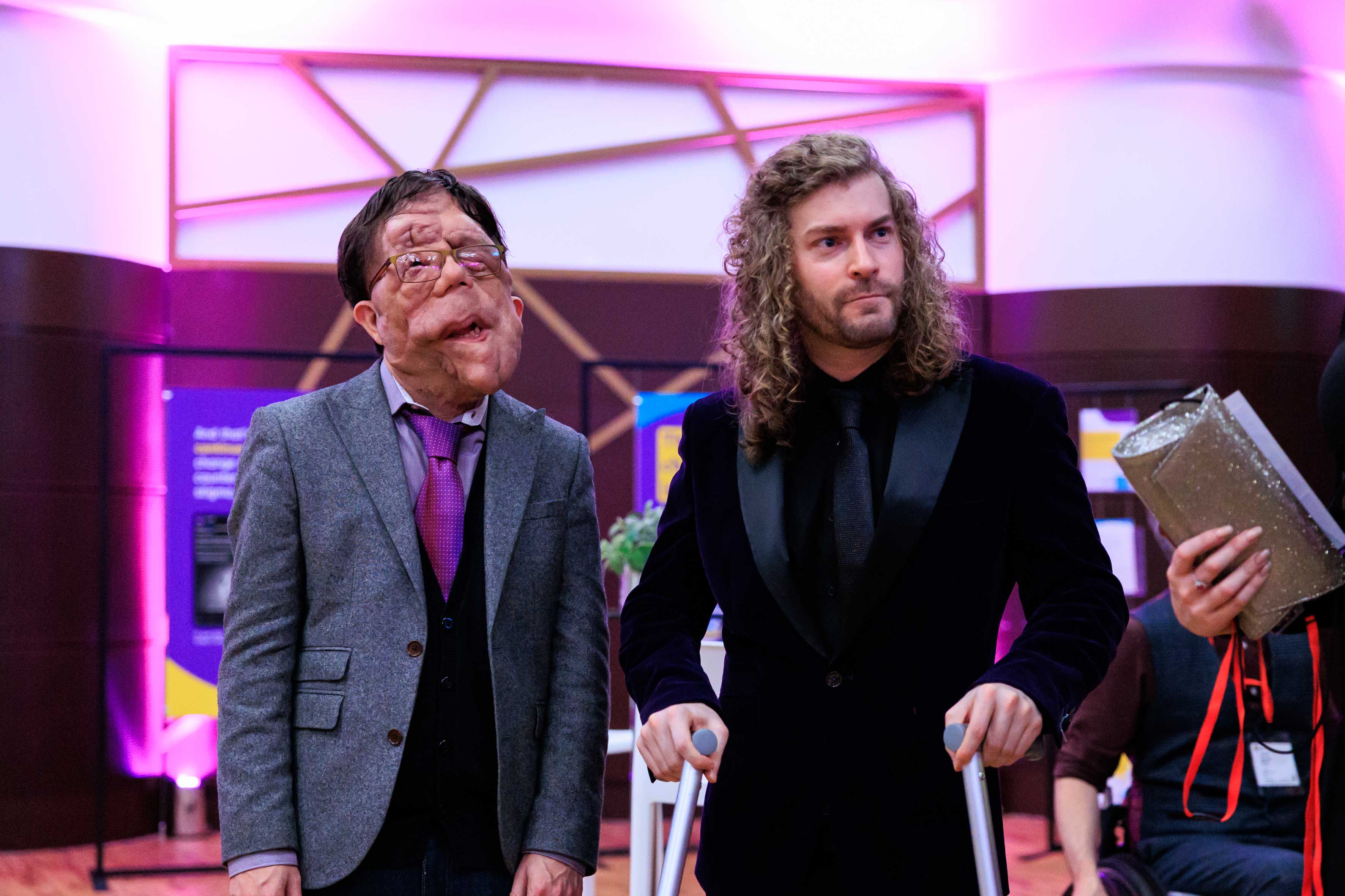 Two men in suits with crutches
