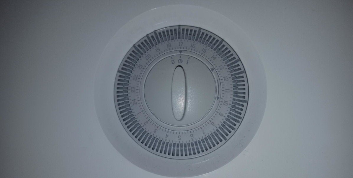 Mechanical heating controls. There's a dial which can be turned with on, off and 1 hour markings. There are switches around the dial arranged in a circle, one for each our of the day which can be set to on or off.