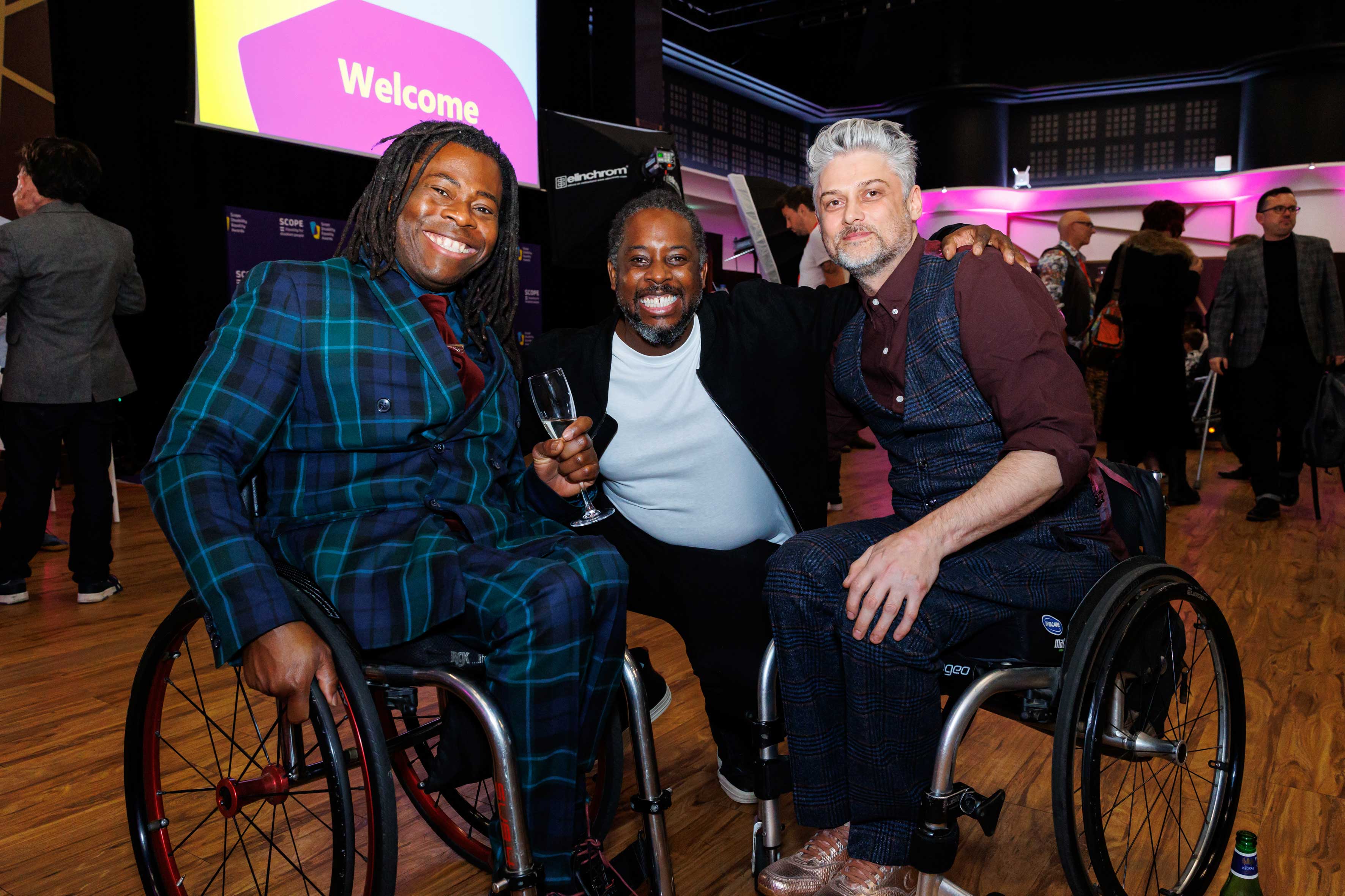 A group of men posing for a photo, 2 in wheelchairs