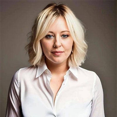 A photo of Dr Steph Blanco. She has medium length blonde hair and wears a white shirt. 