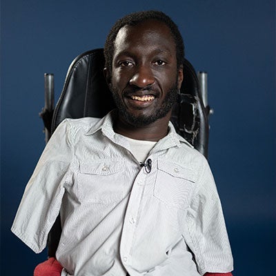 Isaac Harvey smiles at the camera. He has short, dark hair and wears a white shirt.