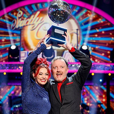 Strictly come Dancing winners Chris McCausland and Diane Buswell pose with their trophy on set.